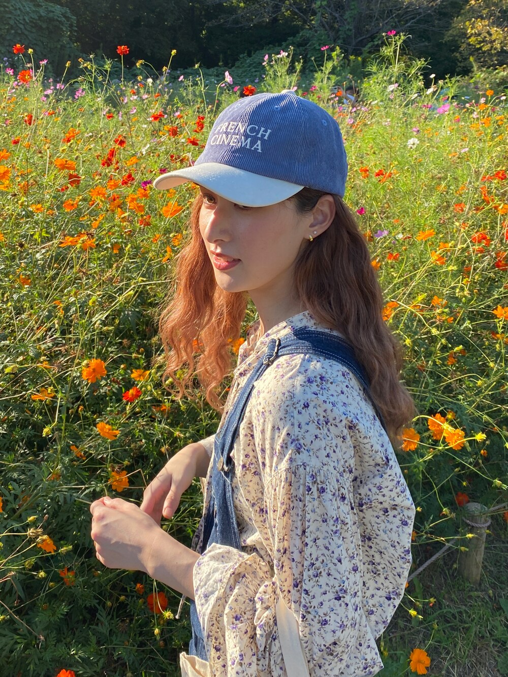 ホワイト系のスニーカー、ブルー系のサロペット/オーバーオール、ホワイト系のシャツ/ブラウスを着用したレディースの秋コーディネートの4枚目の写真