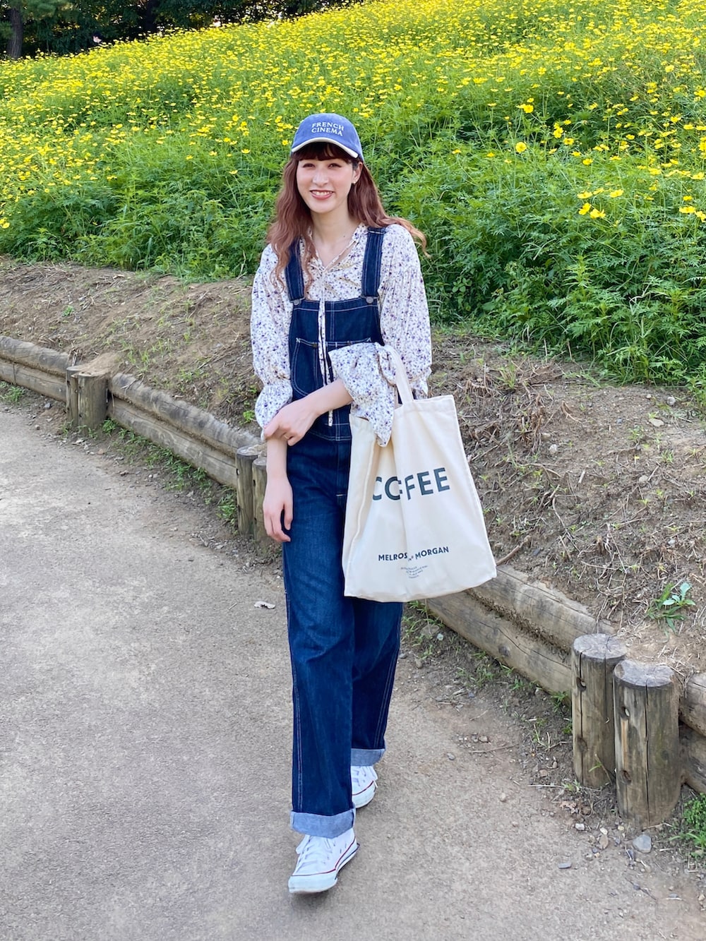 ホワイト系のスニーカー、ブルー系のサロペット/オーバーオール、ホワイト系のシャツ/ブラウスを着用したレディースの秋コーディネートの3枚目の写真