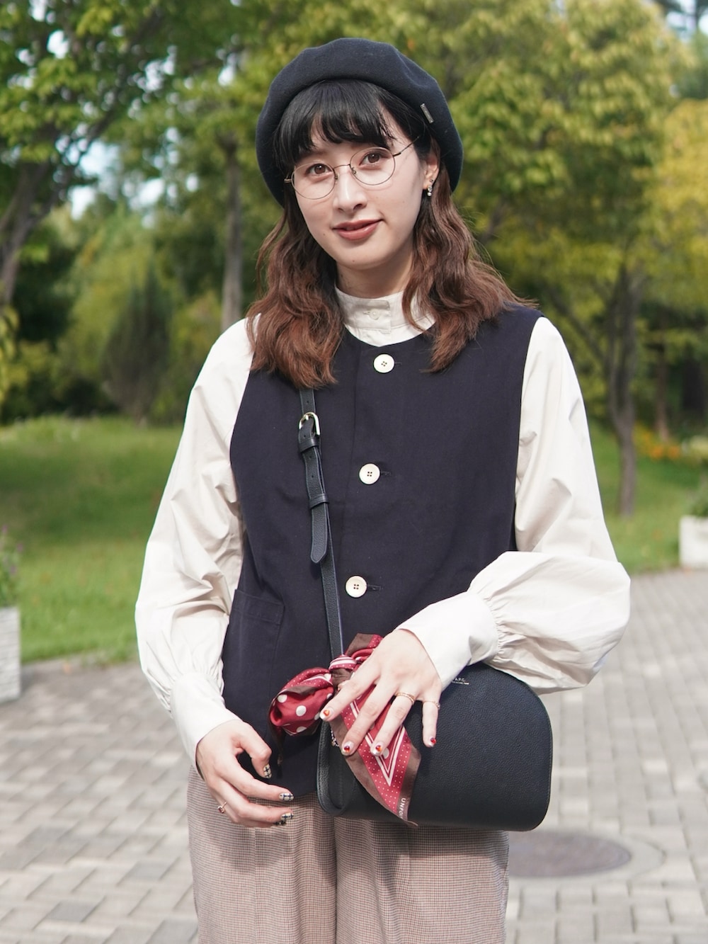 ベージュ系のシャツ/ブラウス、レッド系のスラックス、ブラック系のショルダーバッグを着用したレディースの秋コーディネートの2枚目の写真