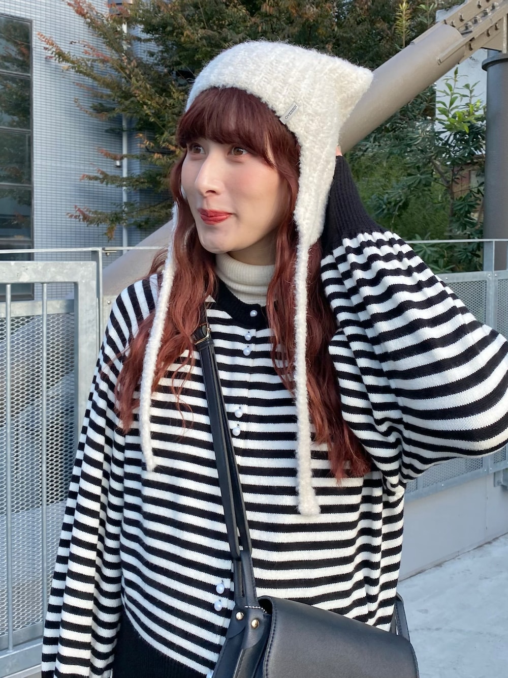 ブラック系のワンピース、ブラック系のカーディガン/ボレロ、ブラック系のショルダーバッグを着用したレディースの冬コーディネートの3枚目の写真