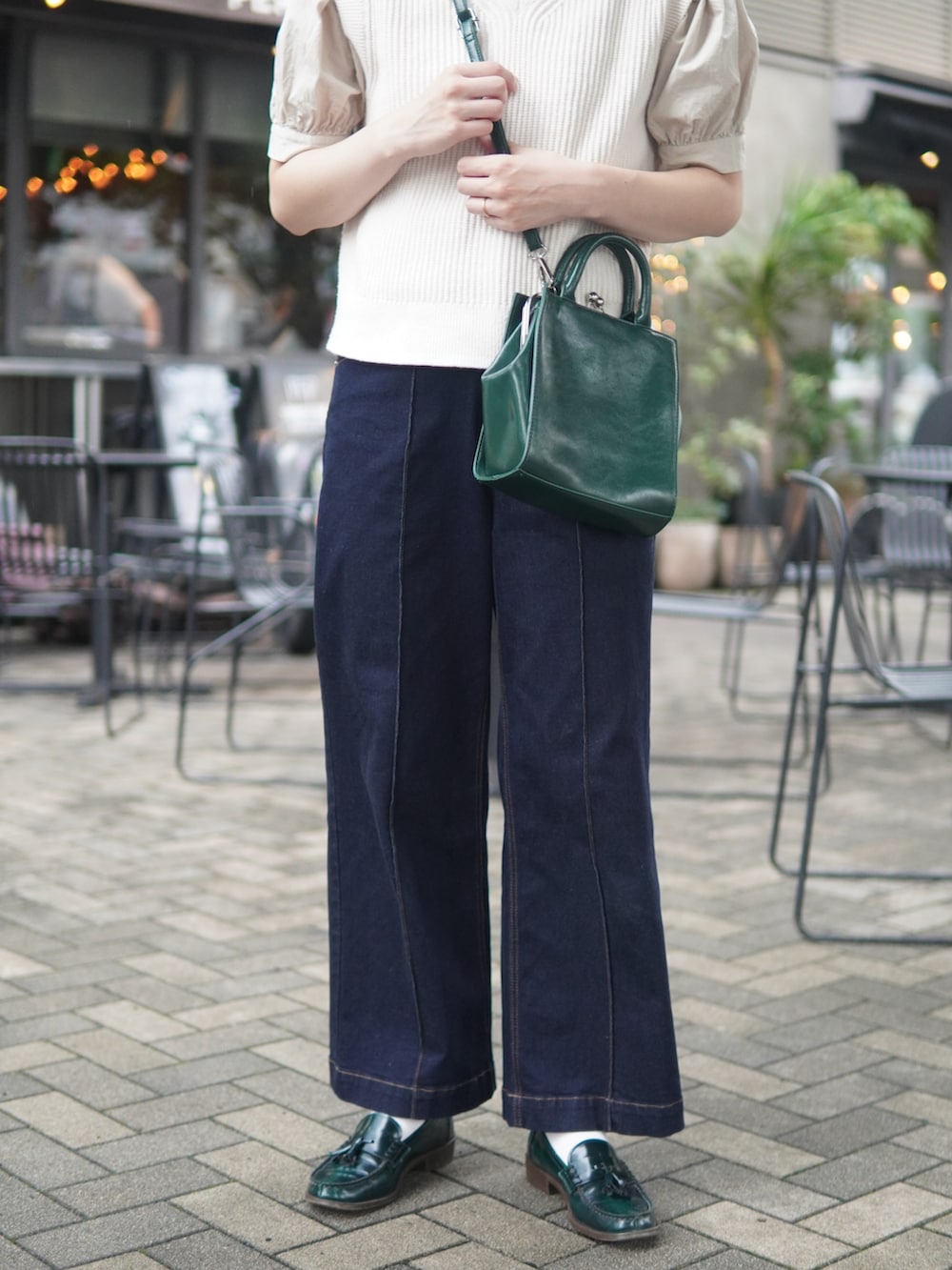 ブルー系のデニムパンツ、グリーン系のショルダーバッグ、グリーン系のローファーを着用したレディースの夏コーディネートの3枚目の写真