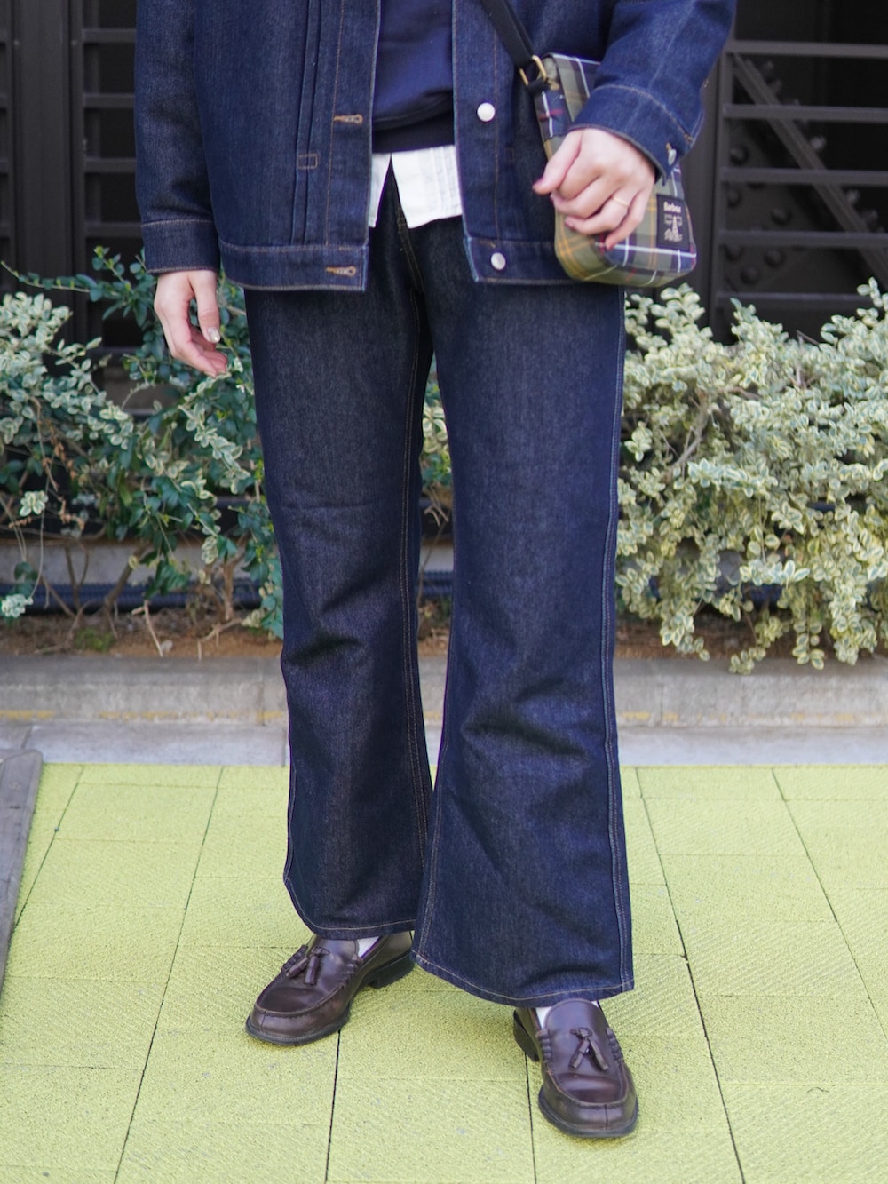 ブルー系のデニムパンツ、ブルー系のデニムジャケット、ブラウン系のローファーを着用したレディースの春コーディネートの4枚目の写真