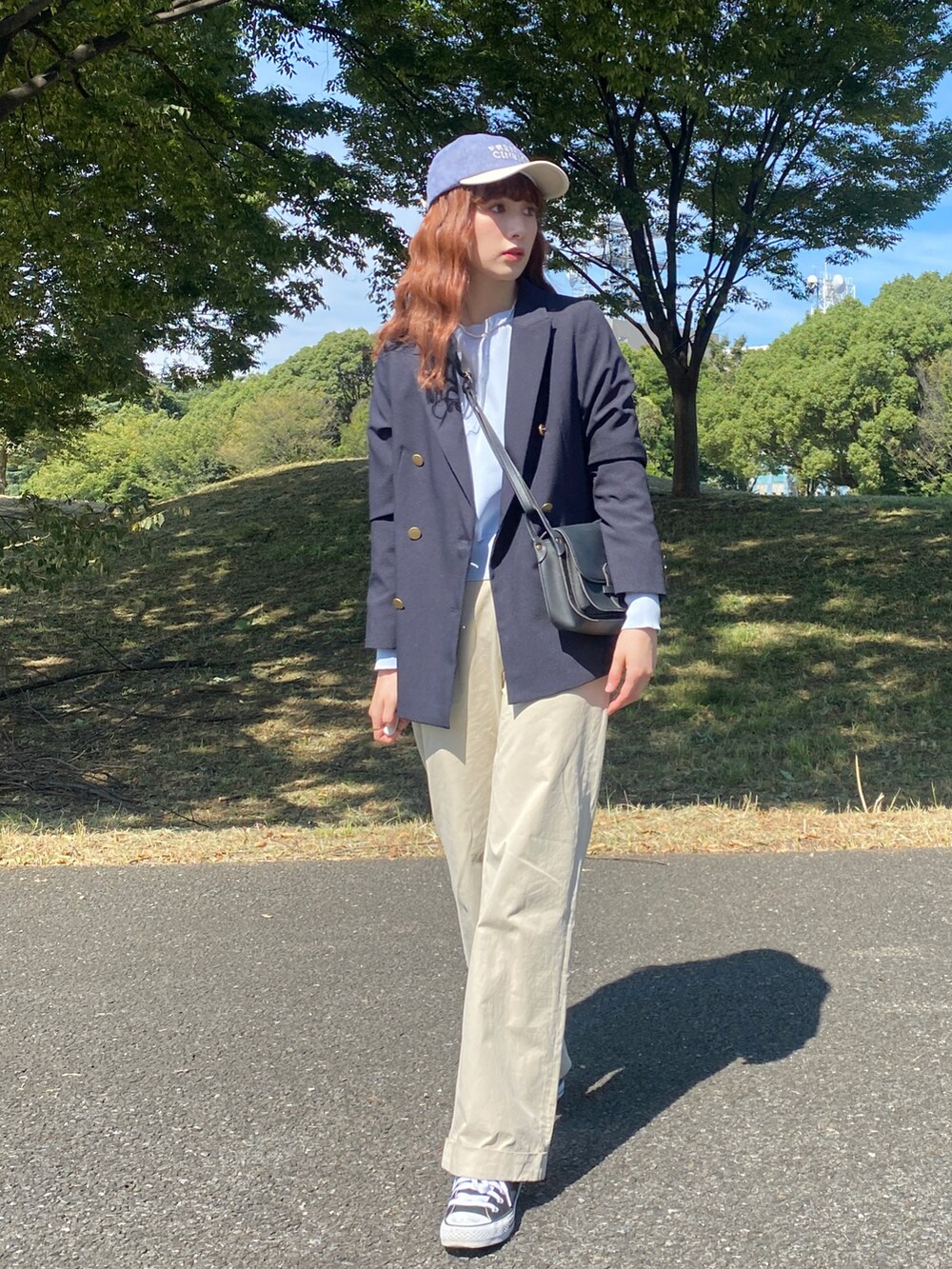 ブラック系のスニーカー、ベージュ系のその他パンツ、ブラック系のショルダーバッグを着用したレディースの秋コーディネートの2枚目の写真