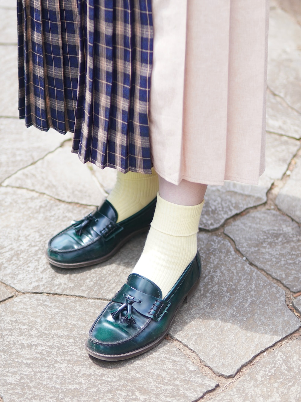 ブルー系のスカート、グリーン系のローファー、ブラウン系のショルダーバッグを着用したレディースの春コーディネートの2枚目の写真