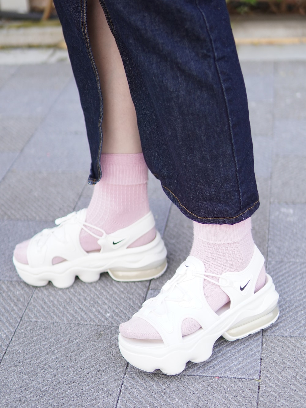 ベージュ系のサンダル、ブルー系のデニムスカート、ブラック系のショルダーバッグを着用したレディースの春コーディネートの3枚目の写真