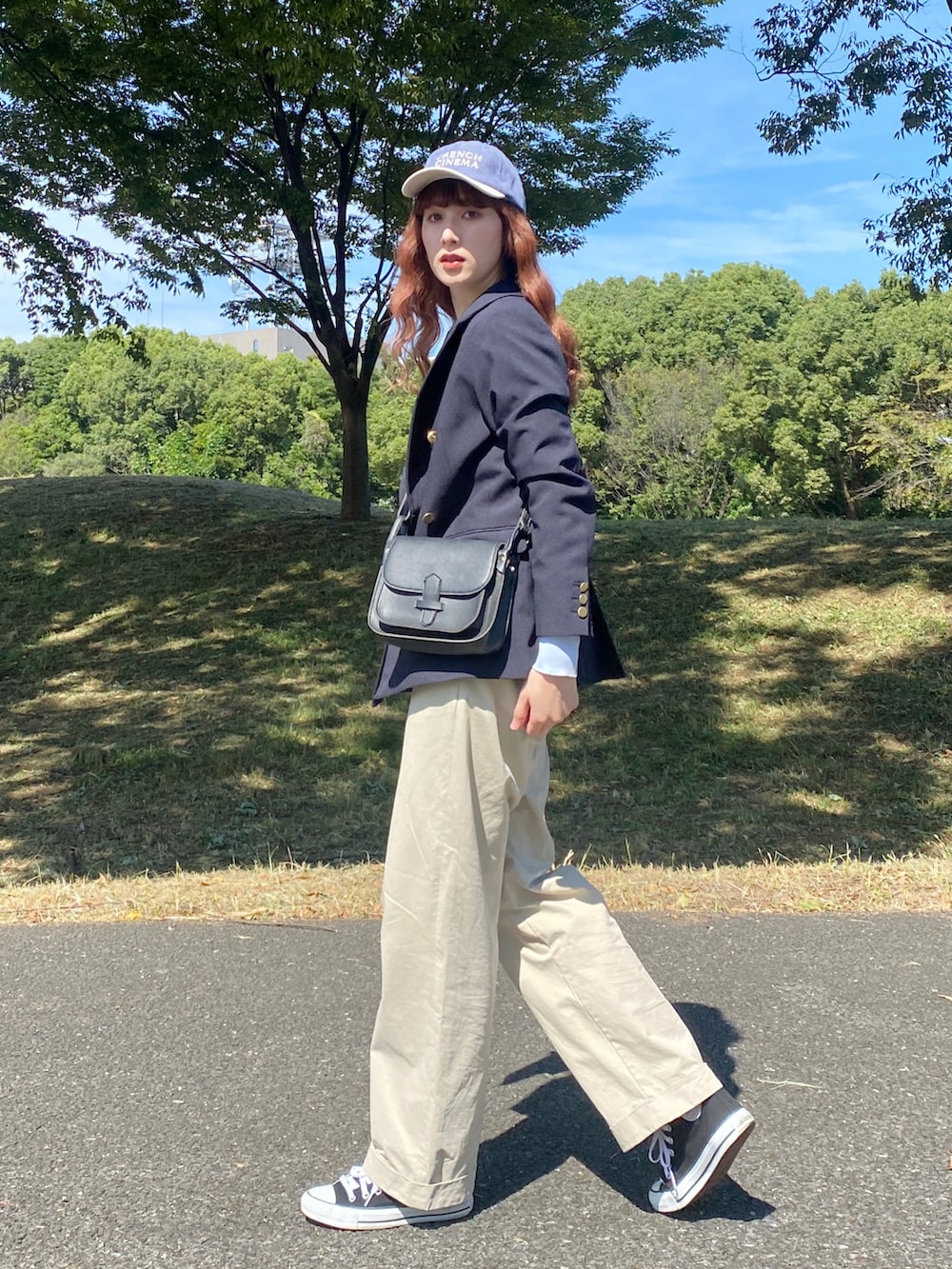 ブラック系のスニーカー、ベージュ系のその他パンツ、ブラック系のショルダーバッグを着用したレディースの秋コーディネートの3枚目の写真