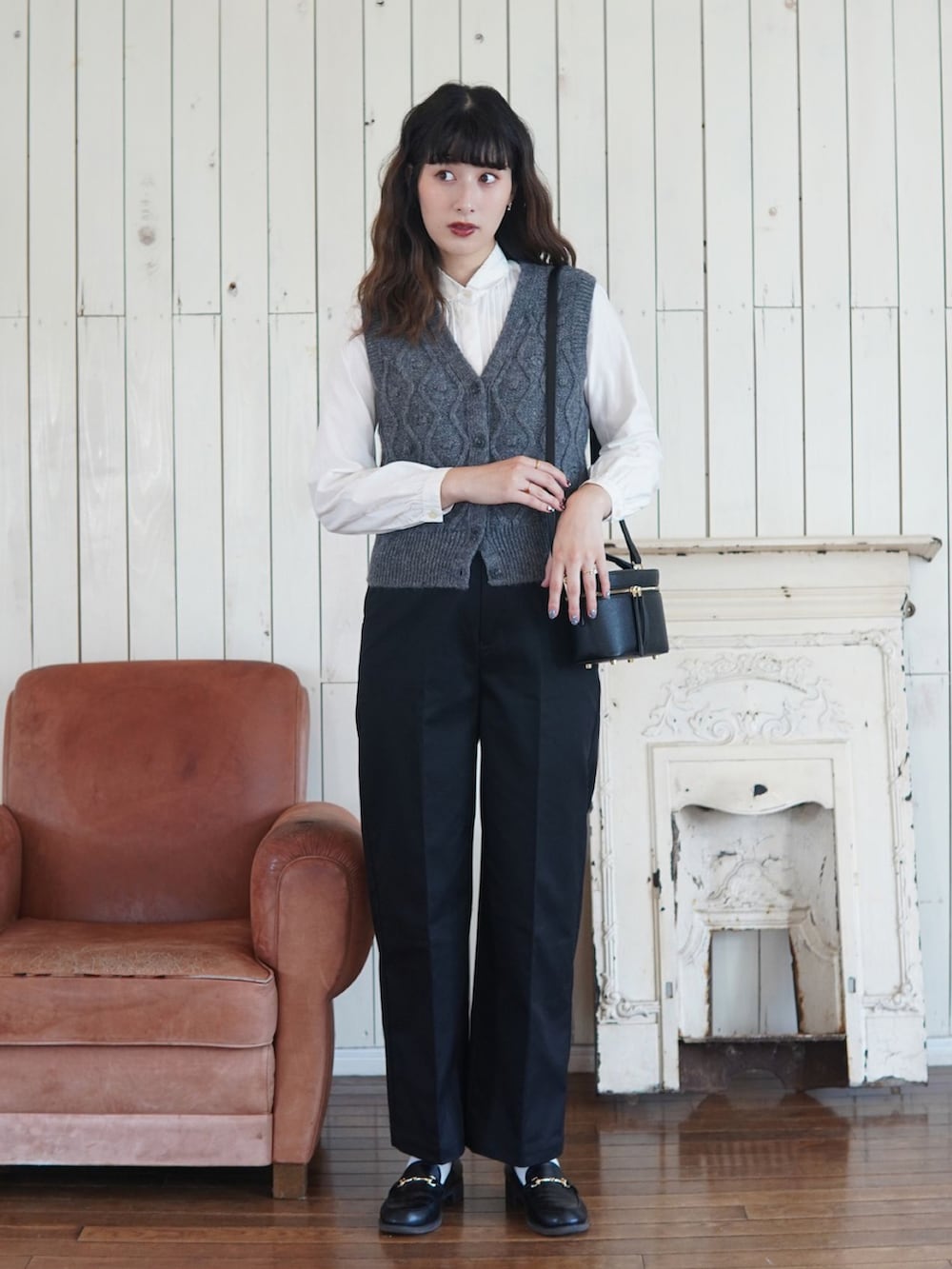 イエロー系のチノパンツ、ブラック系のショルダーバッグ、ブラック系のローファーを着用したレディースの秋コーディネートの2枚目の写真