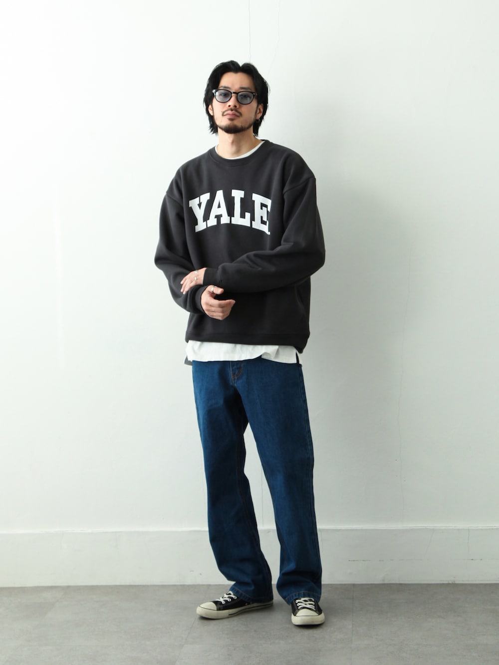 グレー系のスウェット、ブルー系のデニムパンツ、ブラック系のスニーカーを着用したメンズの冬コーディネートの2枚目の写真