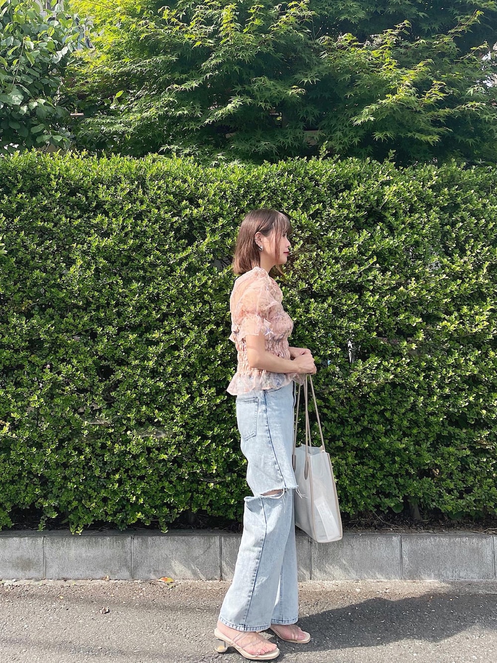 ベージュ系のシャツ/ブラウス、ブルー系のデニムパンツ、ホワイト系のトートバッグを着用したレディースの夏コーディネートの2枚目の写真