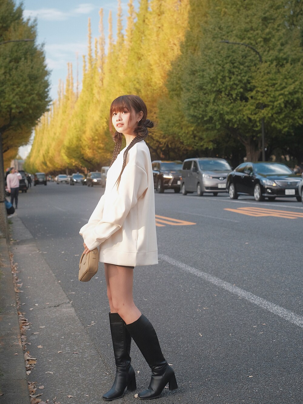 ホワイト系のトップス、ブラック系のブーツ、ブラウン系のバッグを着用したレディースの秋コーディネートの2枚目の写真