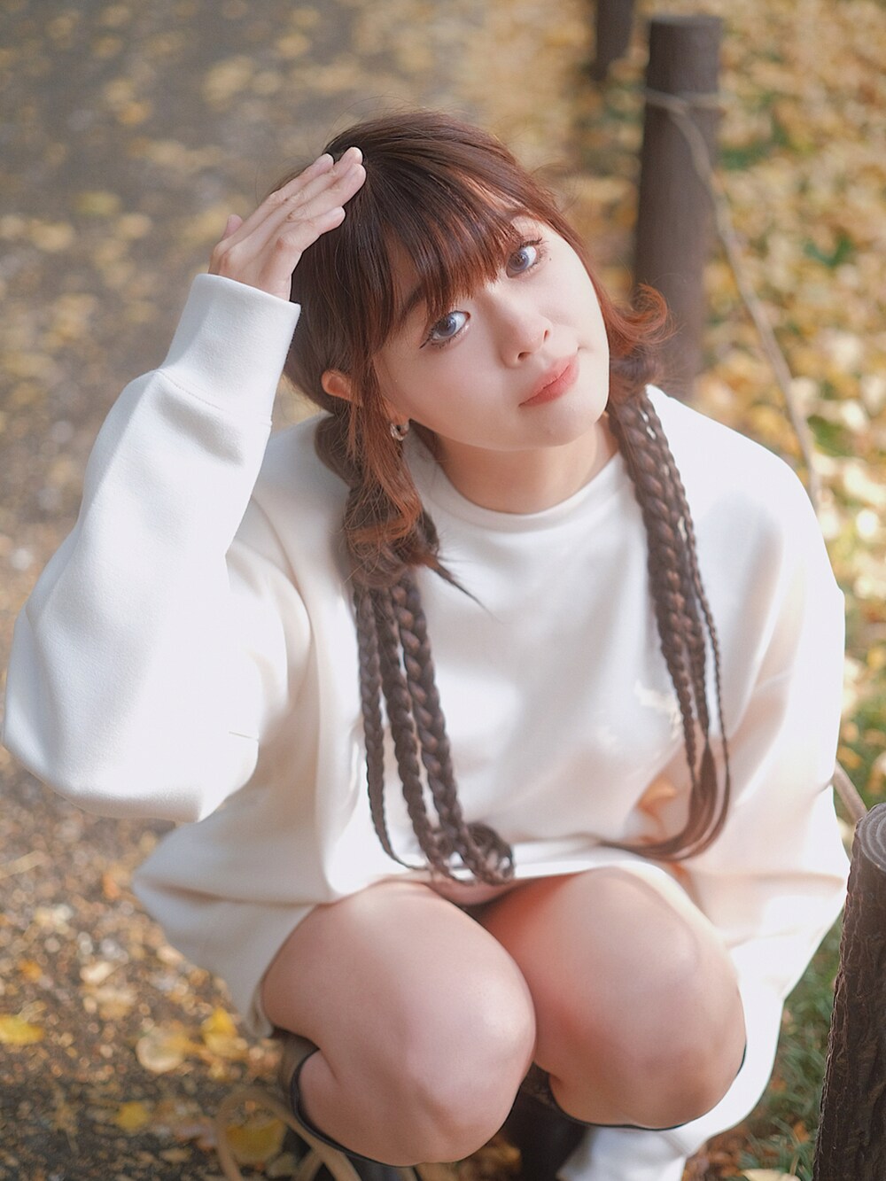 ホワイト系のトップス、ブラック系のブーツ、ブラウン系のバッグを着用したレディースの秋コーディネートの5枚目の写真