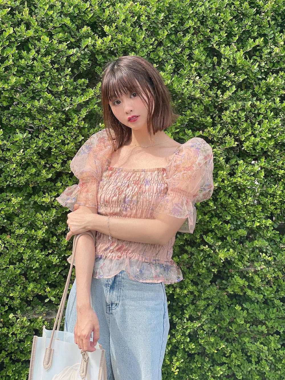 ベージュ系のシャツ/ブラウス、ブルー系のデニムパンツ、ホワイト系のトートバッグを着用したレディースの夏コーディネートの3枚目の写真