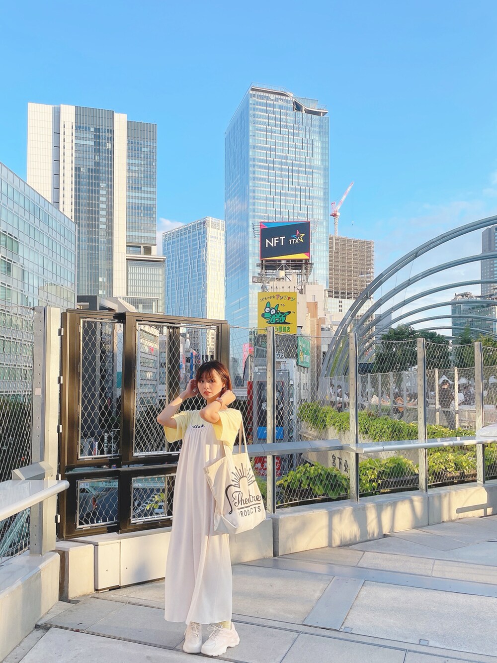 イエロー系のTシャツ/カットソー、ホワイト系のワンピース、ベージュ系のトートバッグを着用したレディースの秋コーディネートの3枚目の写真