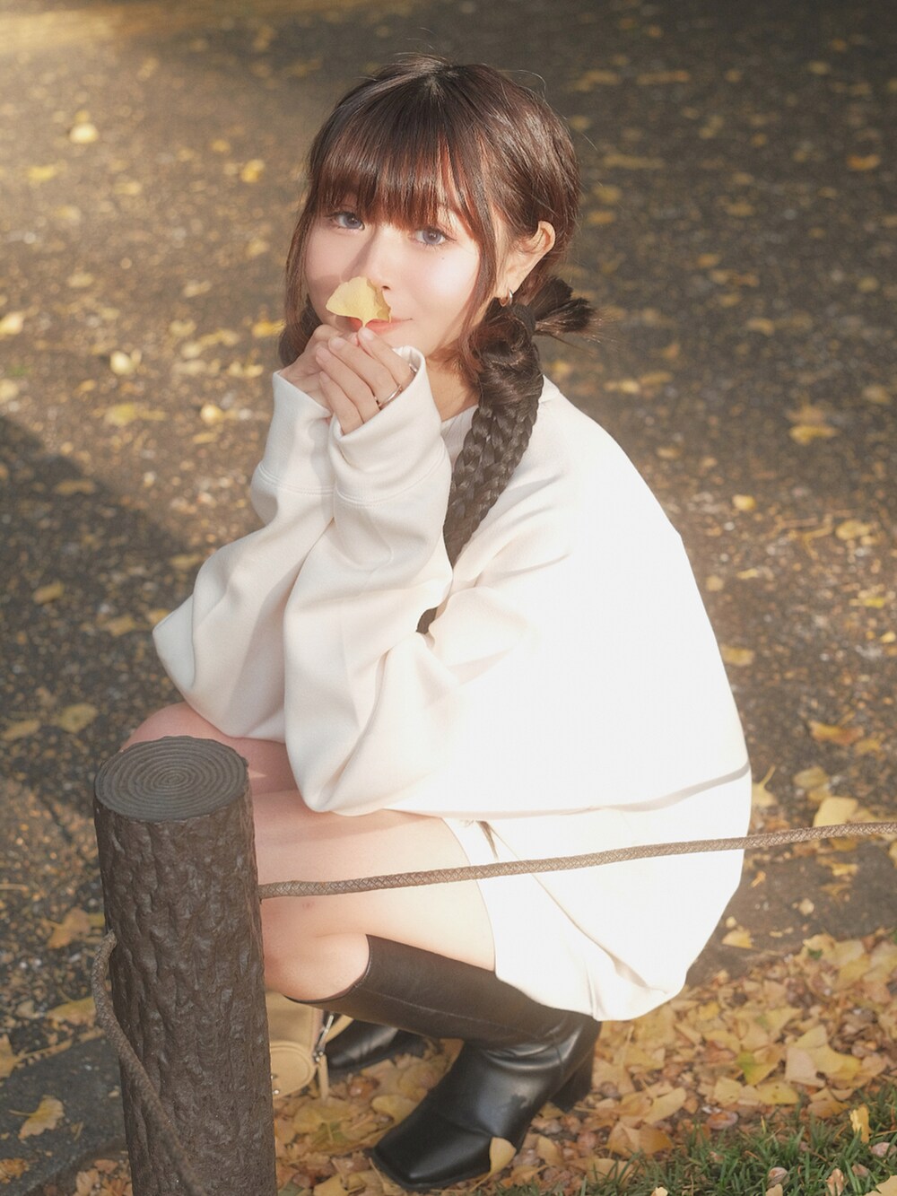 ホワイト系のトップス、ブラック系のブーツ、ブラウン系のバッグを着用したレディースの秋コーディネートの4枚目の写真