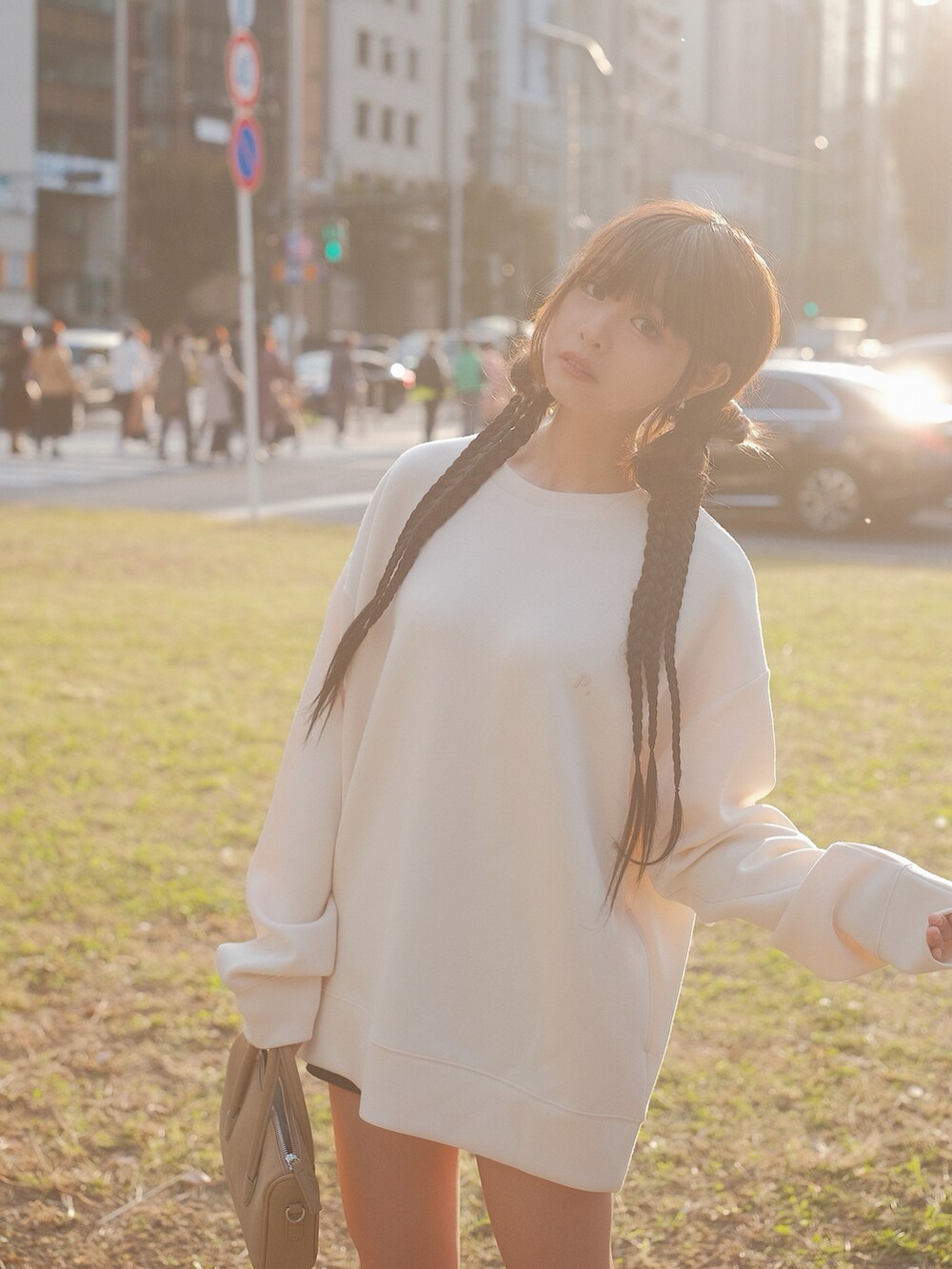 ホワイト系のトップス、ブラック系のブーツ、ブラウン系のバッグを着用したレディースの秋コーディネートの3枚目の写真