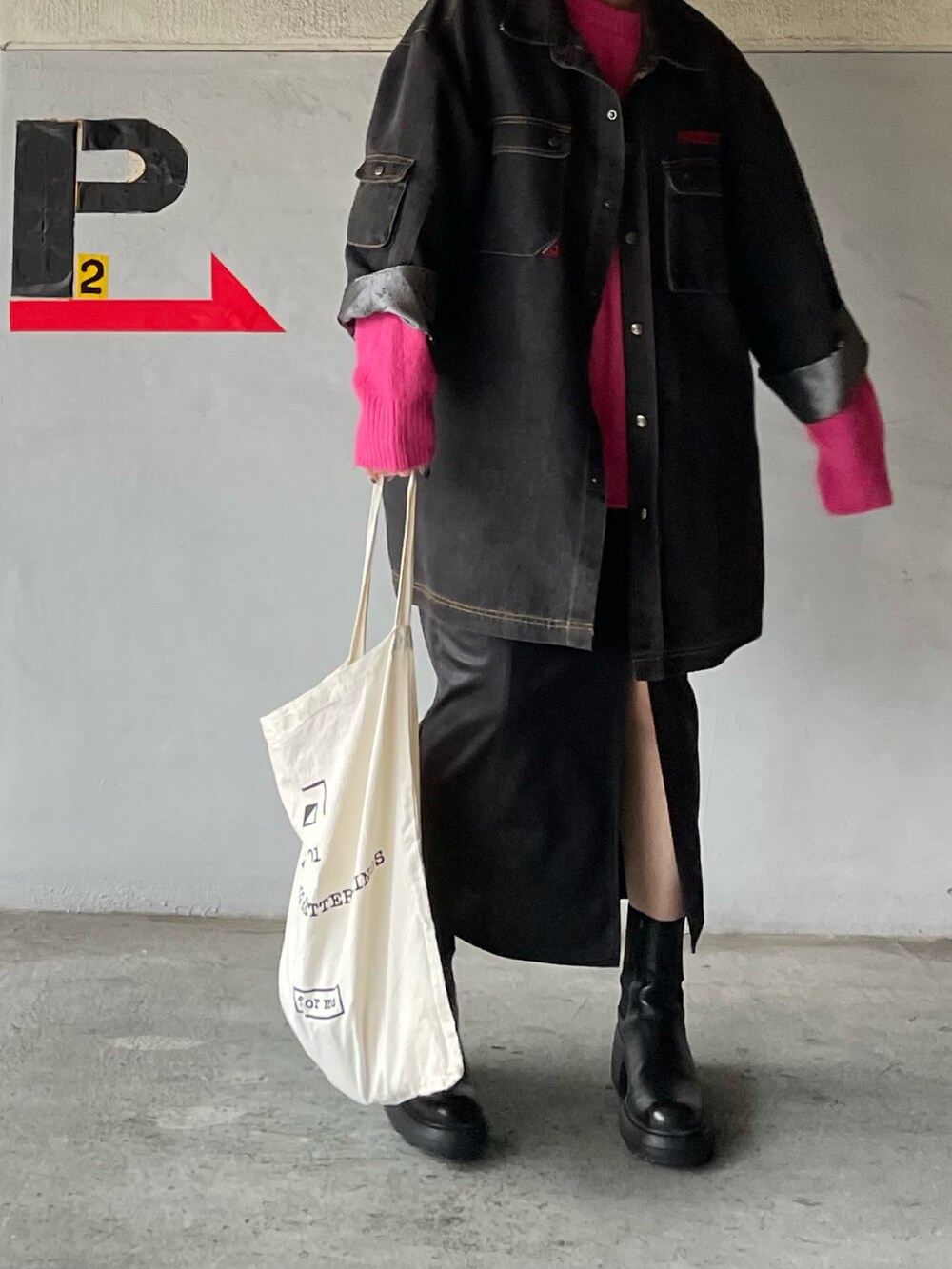 ピンク系のニット/セーター、ブラック系のブーツ、ブラック系のスカートを着用したレディースの秋コーディネートの2枚目の写真