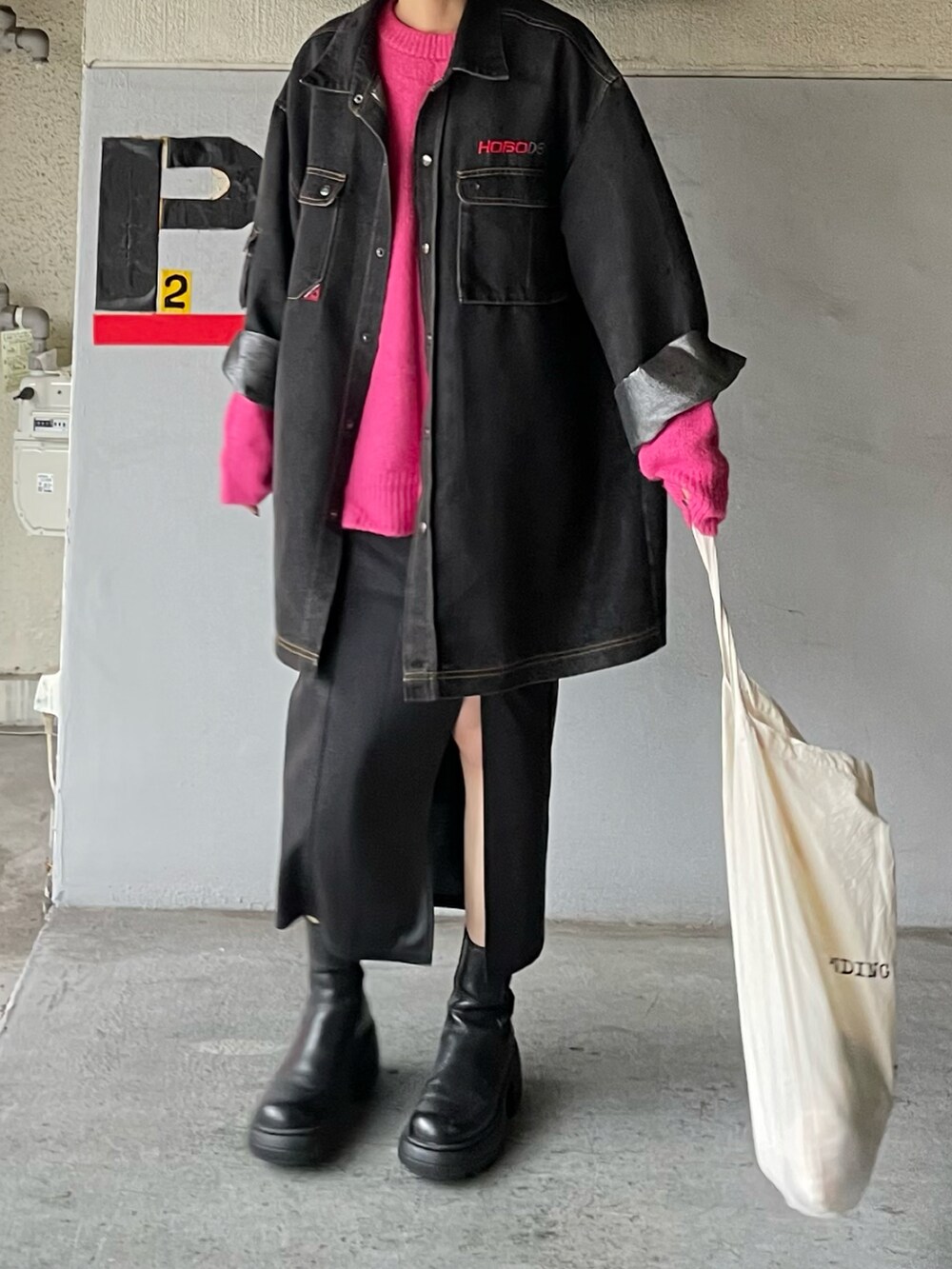 ピンク系のニット/セーター、ブラック系のブーツ、ブラック系のスカートを着用したレディースの秋コーディネートの4枚目の写真