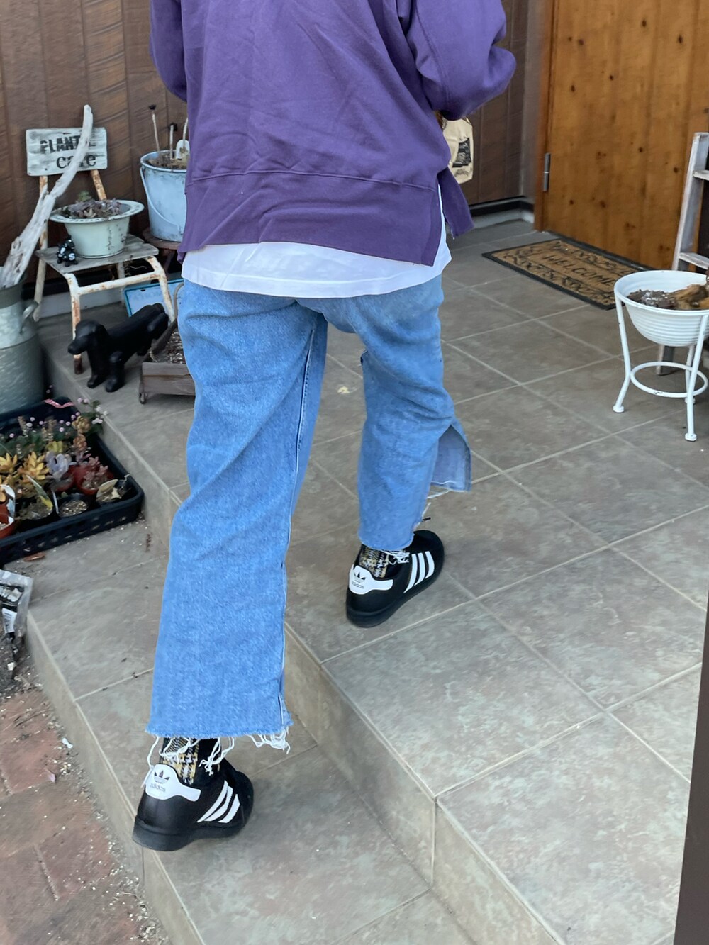 ブルー系のデニムパンツ、パープル系のスウェット、ブラック系のスニーカーを着用したレディースの秋コーディネートの4枚目の写真