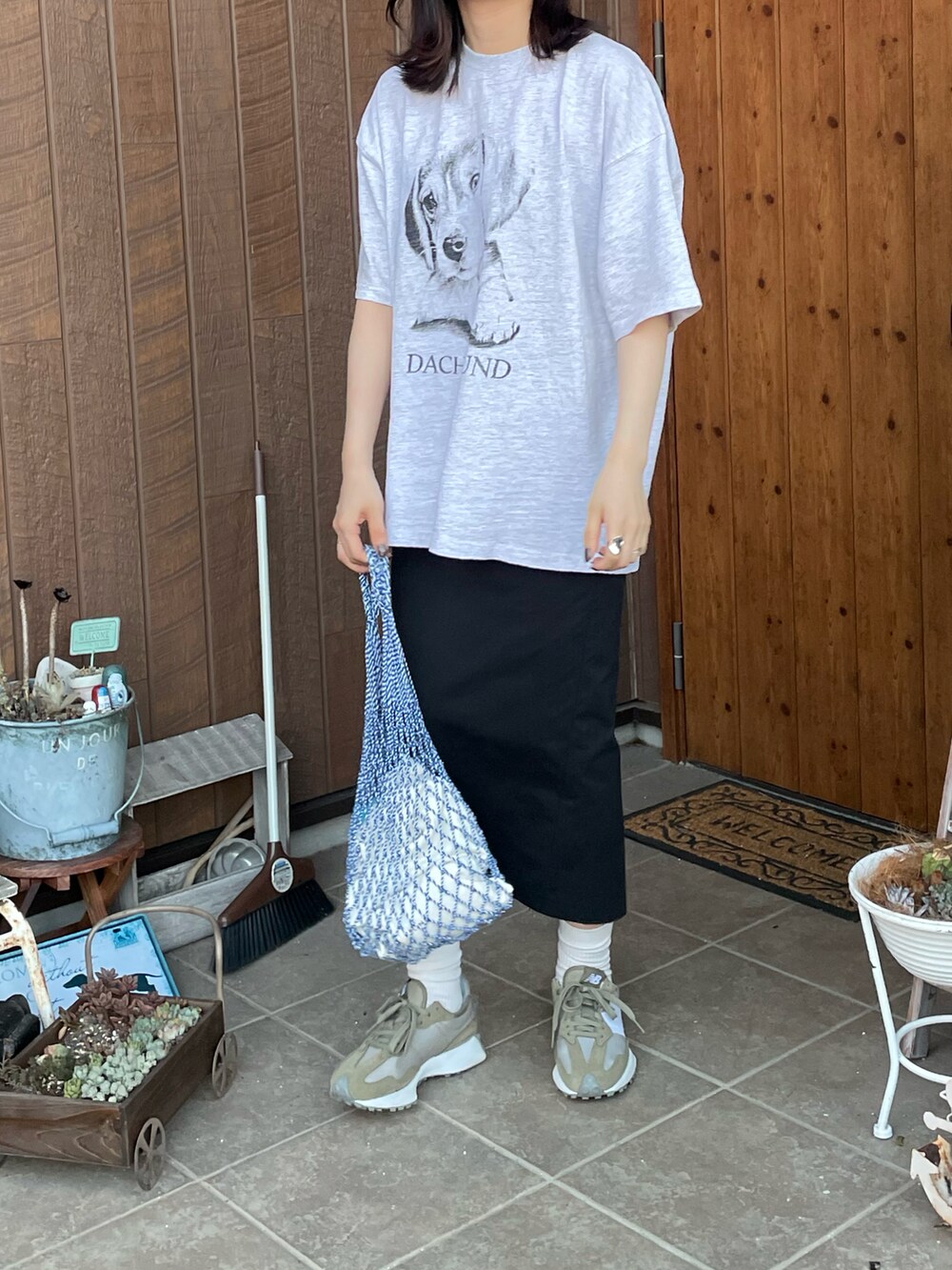 グレー系のTシャツ/カットソー、ブルー系のバッグ、グリーン系のスニーカーを着用したレディースの秋コーディネートの3枚目の写真