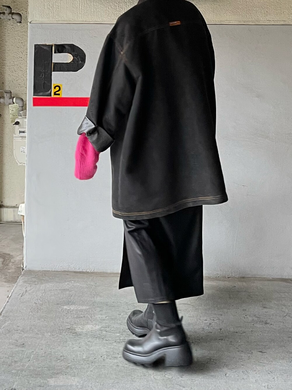 ピンク系のニット/セーター、ブラック系のブーツ、ブラック系のスカートを着用したレディースの秋コーディネートの3枚目の写真