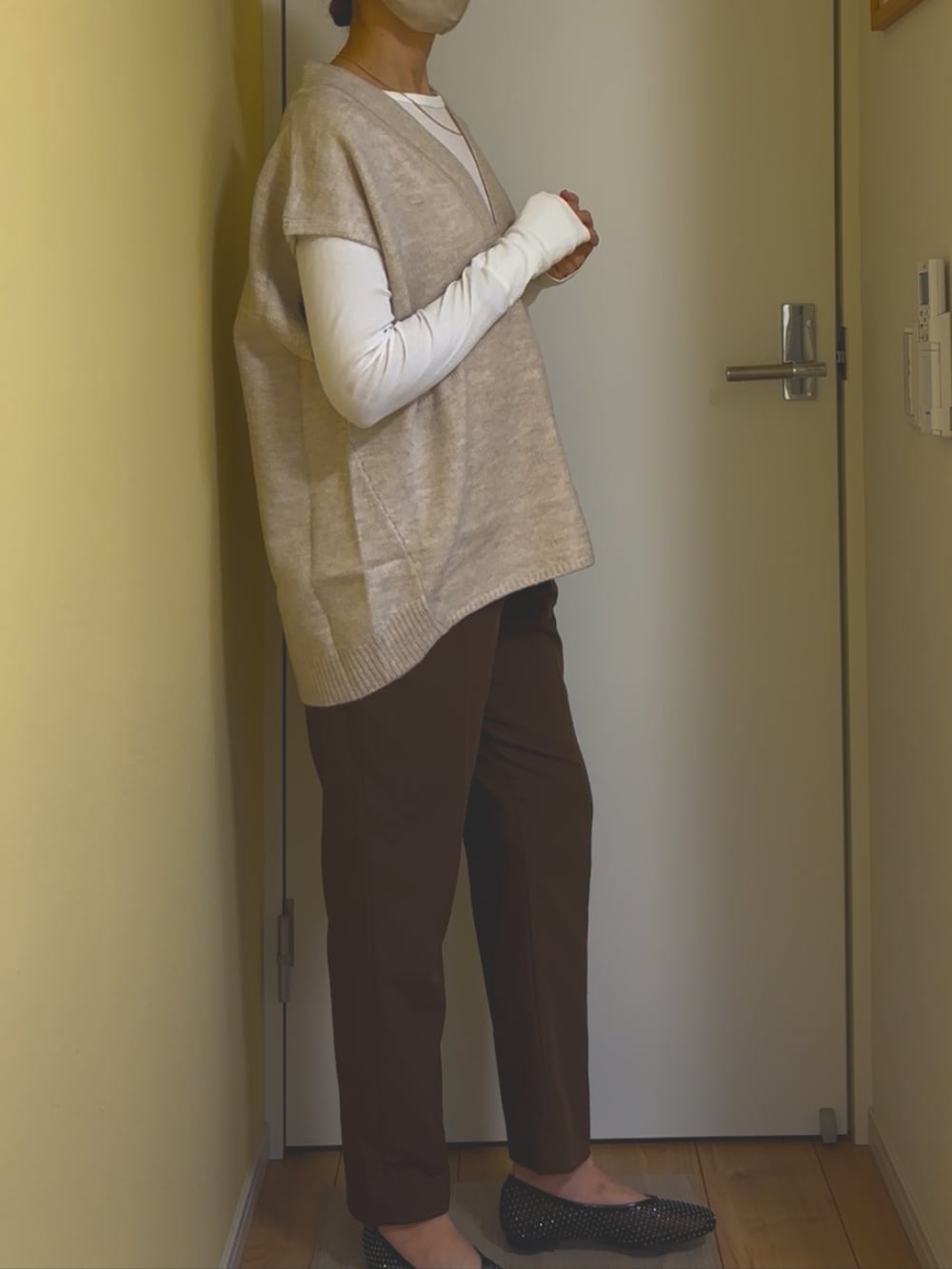 ホワイト系のベストを着用したレディースの冬コーディネートの2枚目の写真