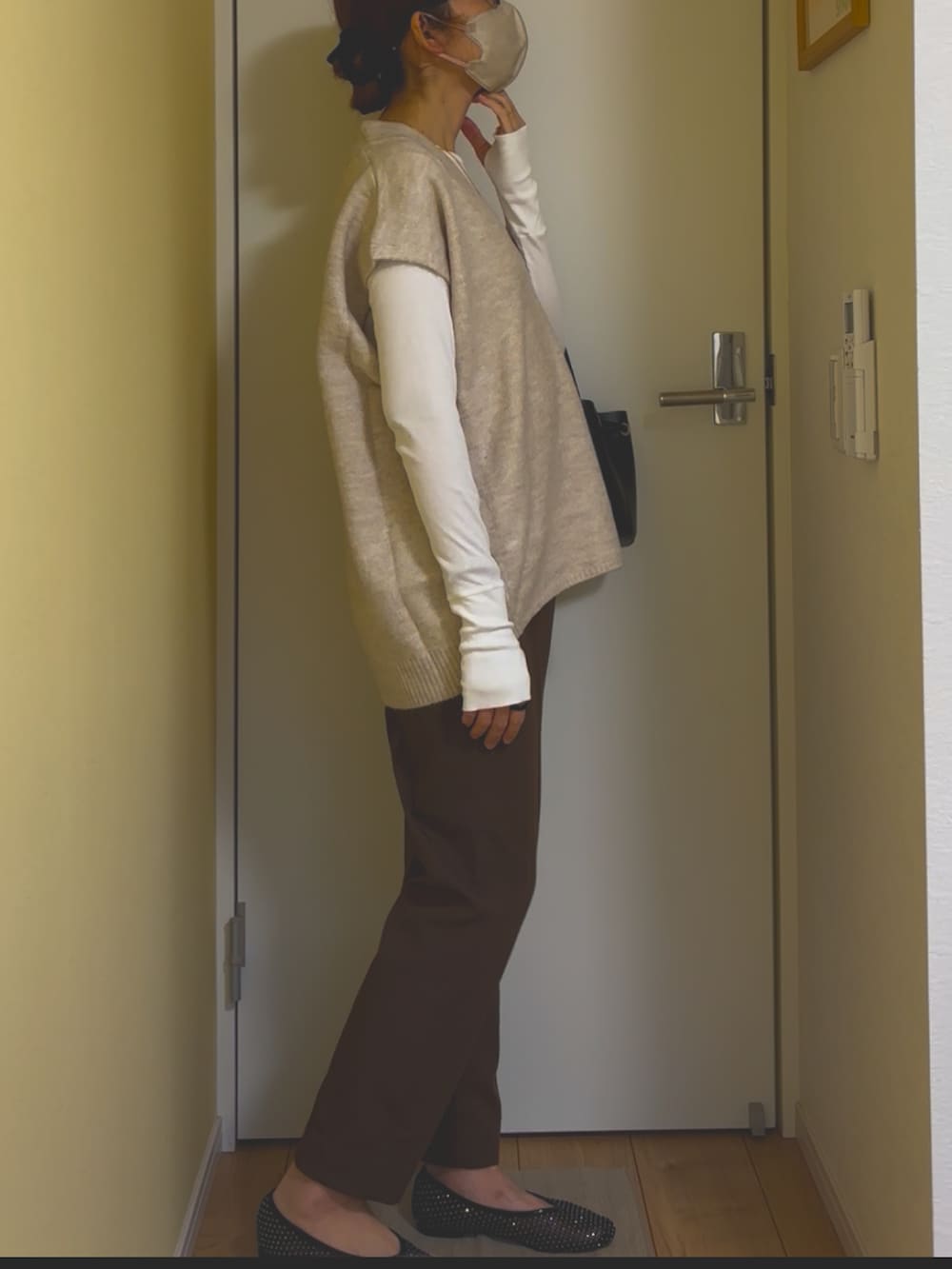 ホワイト系のベストを着用したレディースの冬コーディネートの3枚目の写真