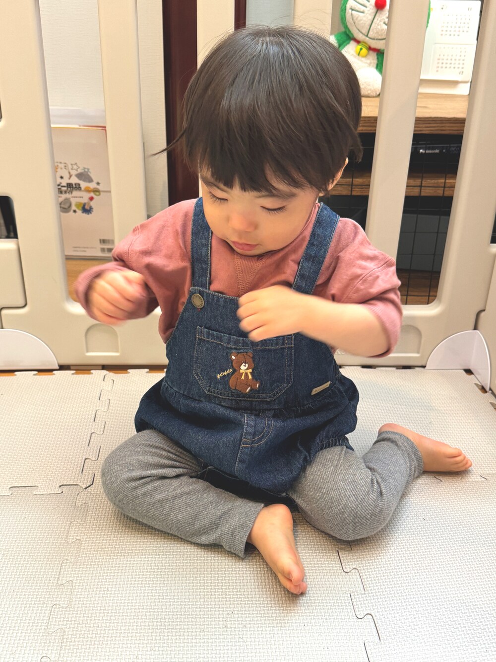 ブルー系のサロペット/オーバーオール、レッド系のTシャツ/カットソー、グレー系のその他パンツを着用したキッズの秋コーディネートの2枚目の写真