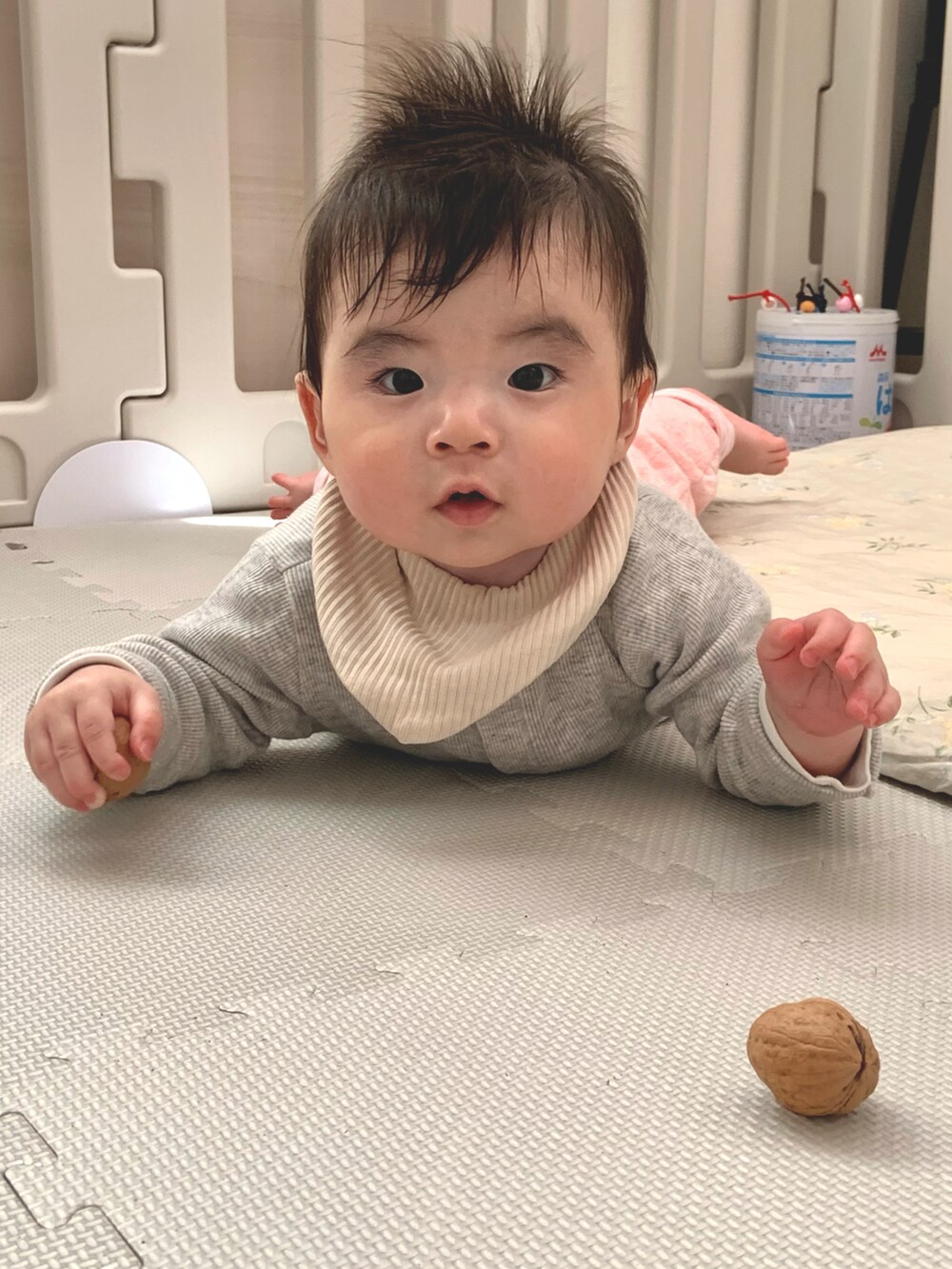 ピンク系のスウェットパンツ、グレー系のカーディガン/ボレロ、ベージュ系のスタイ/よだれかけを着用したキッズの春コーディネートの2枚目の写真