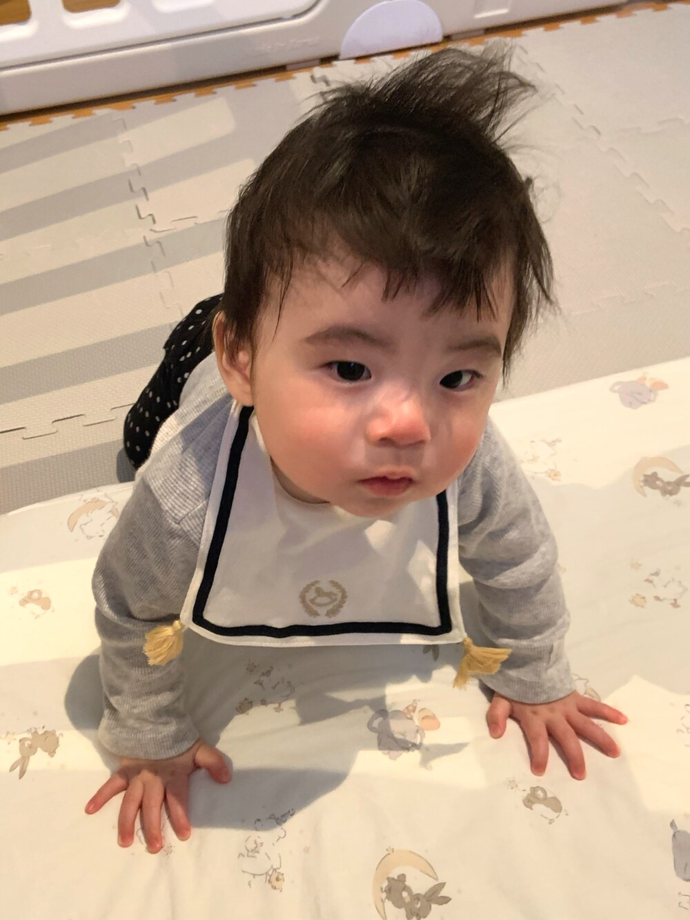 グレー系のカーディガン/ボレロ、ブラック系のその他パンツ、ホワイト系のスタイ/よだれかけを着用したキッズの春コーディネートの2枚目の写真