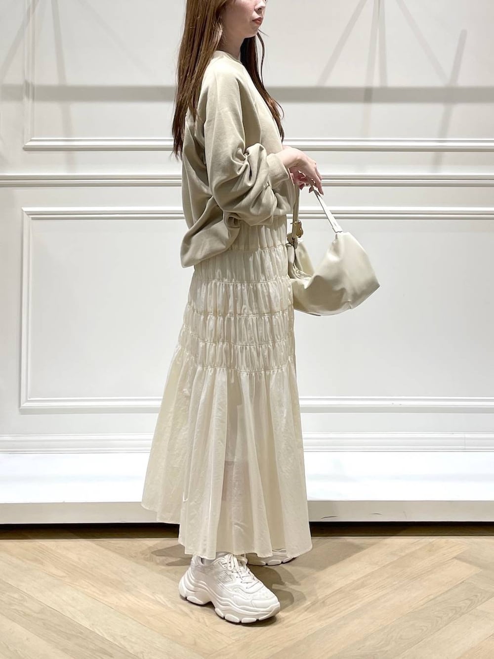 ホワイト系のスカート、ベージュ系のスウェットを着用したレディースの冬コーディネートの3枚目の写真