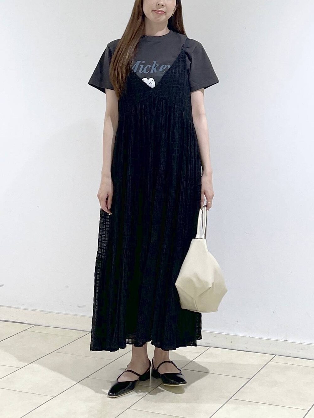 ホワイト系のショルダーバッグ、ブラック系のパンプス、グレー系のTシャツ/カットソーを着用したレディースの春コーディネートの2枚目の写真