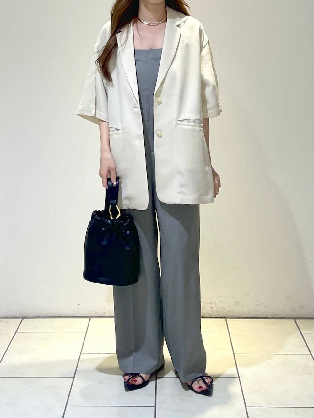 グレー系のサロペット/オーバーオール、ホワイト系のテーラードジャケット、ブラック系のサンダルを着用したレディースの夏コーディネートの5枚目の写真