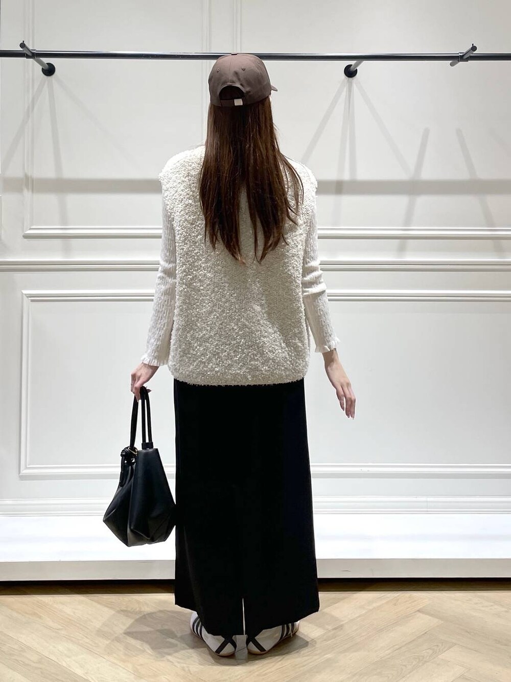 ブラック系のショルダーバッグ、ホワイト系のスニーカー、ホワイト系のTシャツ/カットソーを着用したレディースの冬コーディネートの4枚目の写真