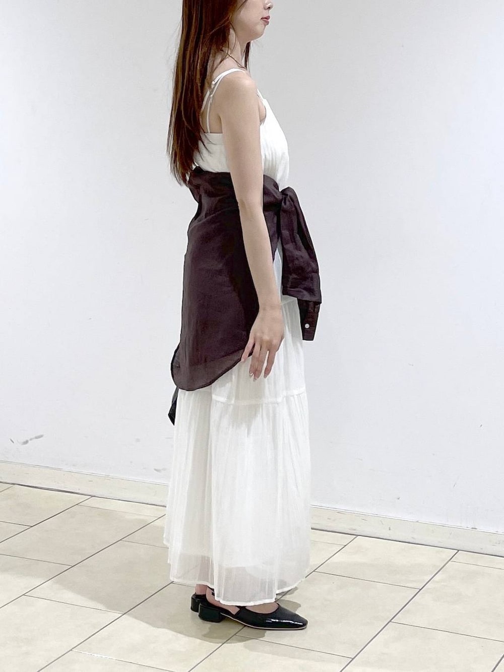 ブラック系のショルダーバッグ、ブラック系のパンプス、ブラウン系のシャツ/ブラウスを着用したレディースの夏コーディネートの3枚目の写真