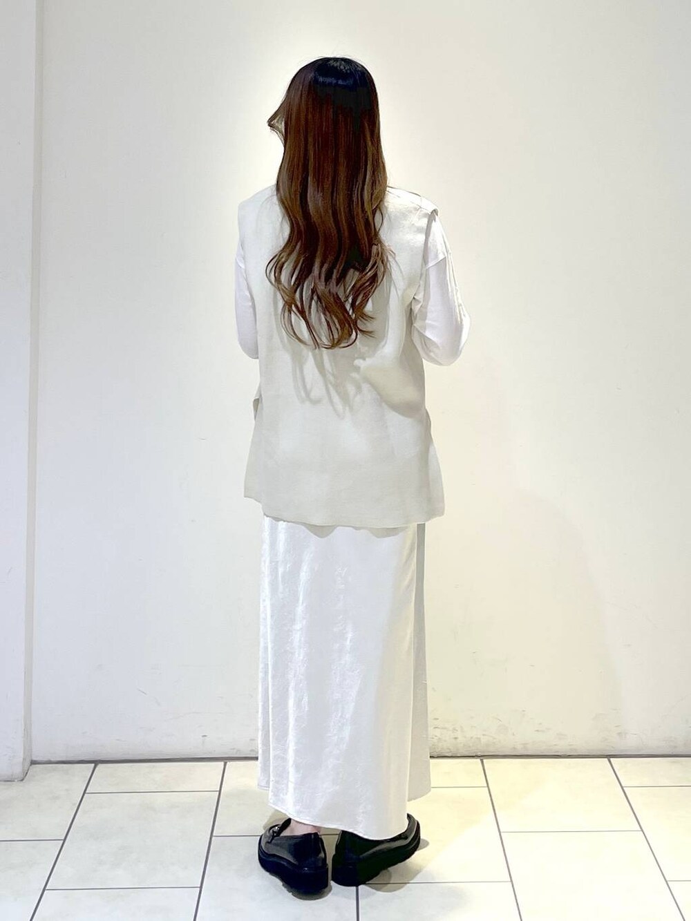 ブラック系のローファー、ベージュ系のベスト、ベージュ系のスカートを着用したレディースの春コーディネートの4枚目の写真