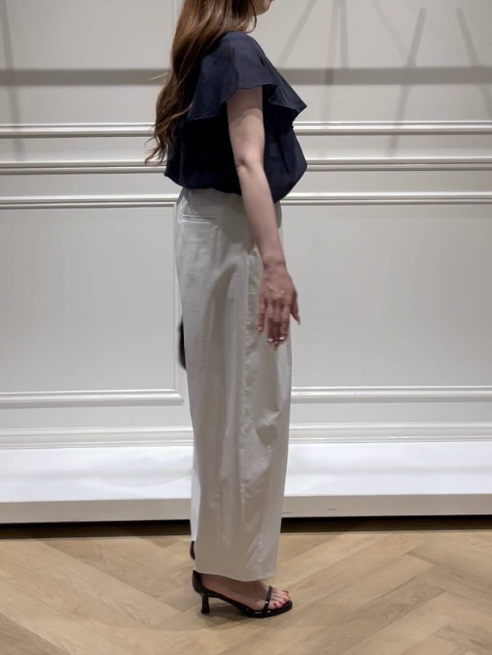 ブラック系のハンドバッグ、ブラック系のサンダル、ホワイト系のその他パンツを着用したレディースの夏コーディネートの2枚目の写真