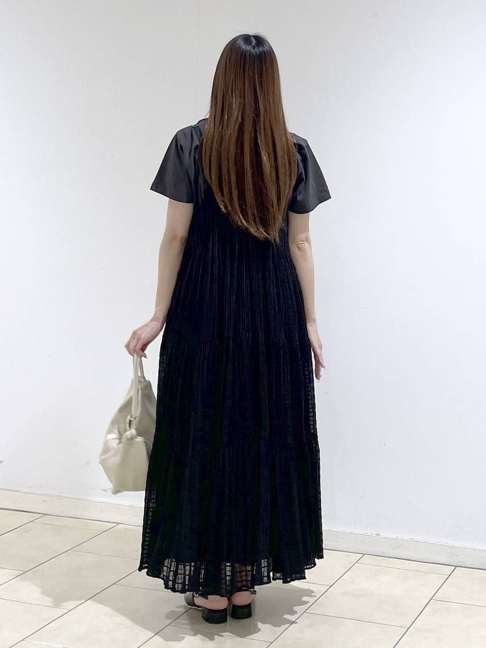 ホワイト系のショルダーバッグ、ブラック系のパンプス、グレー系のTシャツ/カットソーを着用したレディースの春コーディネートの4枚目の写真
