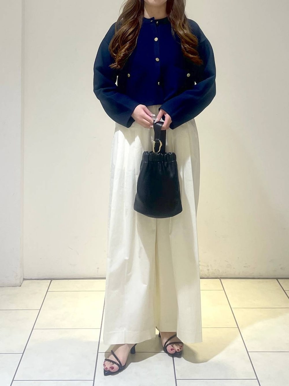 ブラック系のサンダル、ブラック系のショルダーバッグ、ホワイト系のその他パンツを着用したレディースの春コーディネートの2枚目の写真