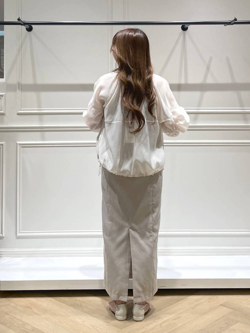 ホワイト系のハンドバッグ、ホワイト系のブルゾン、ホワイト系のサンダルを着用したレディースの春コーディネートの4枚目の写真