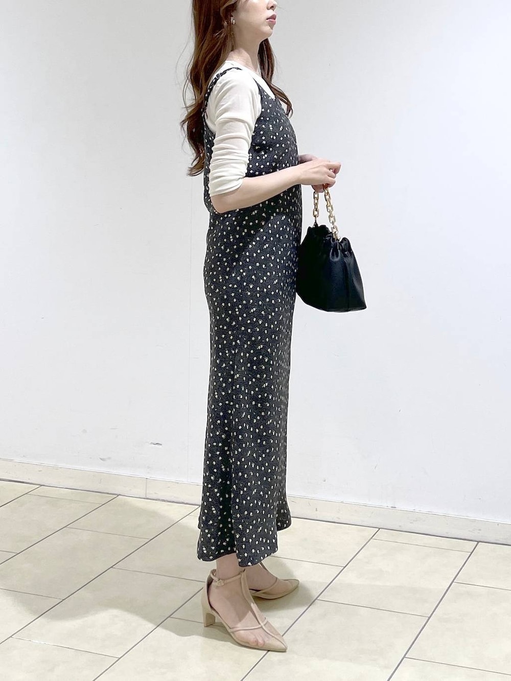 ブラック系のショルダーバッグ、ホワイト系のTシャツ/カットソー、ブラック系のワンピースを着用したレディースの春コーディネートの3枚目の写真