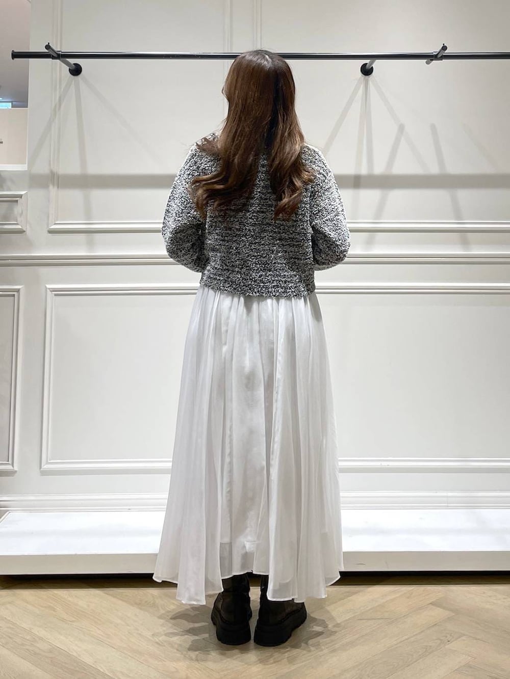 ブラック系のショルダーバッグ、ホワイト系のスカート、ブラック系のカーディガン/ボレロを着用したレディースの冬コーディネートの4枚目の写真