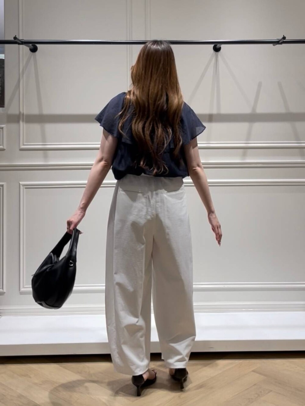 ブラック系のハンドバッグ、ブラック系のサンダル、ホワイト系のその他パンツを着用したレディースの夏コーディネートの3枚目の写真