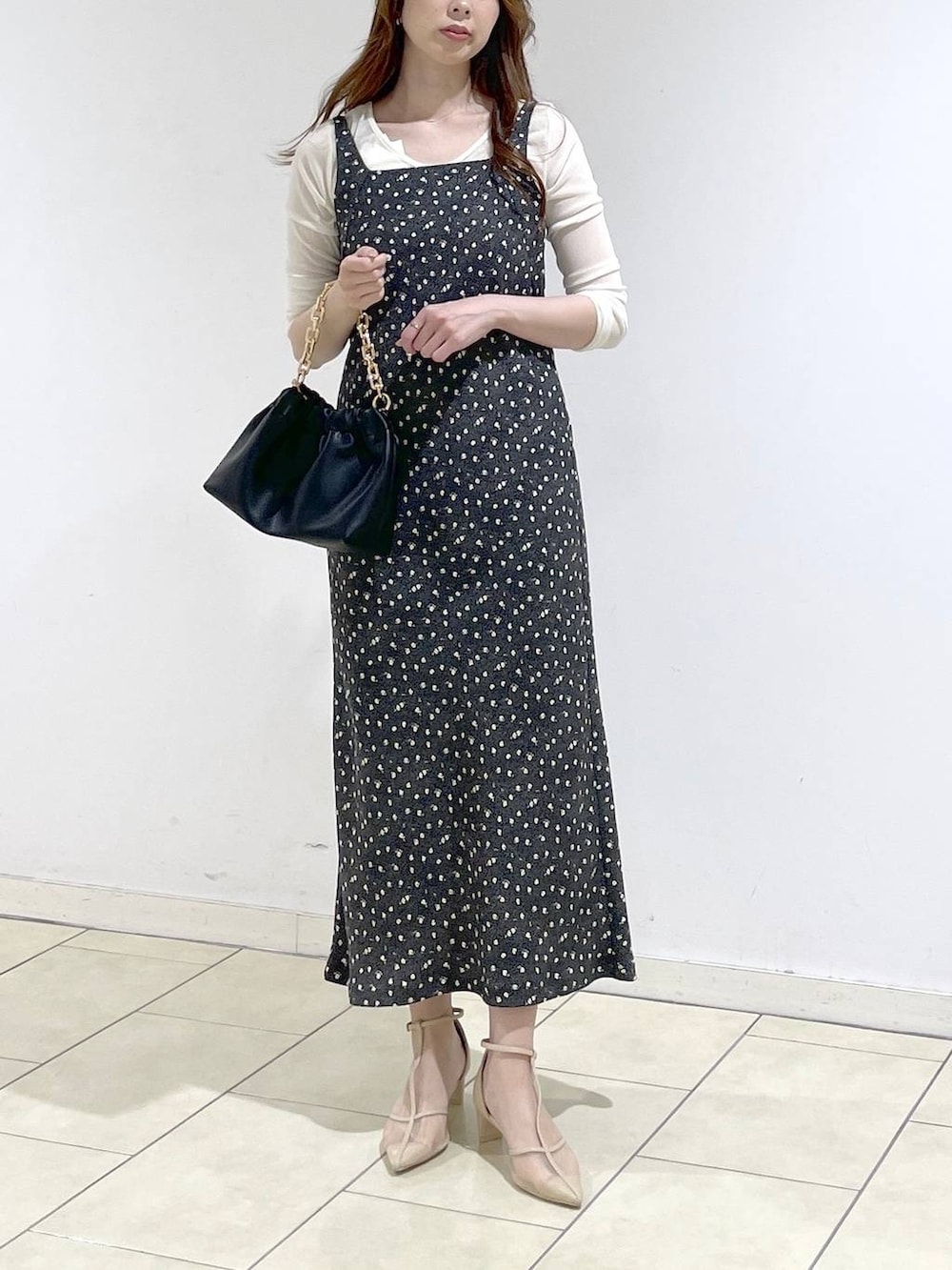 ブラック系のショルダーバッグ、ホワイト系のTシャツ/カットソー、ブラック系のワンピースを着用したレディースの春コーディネートの2枚目の写真