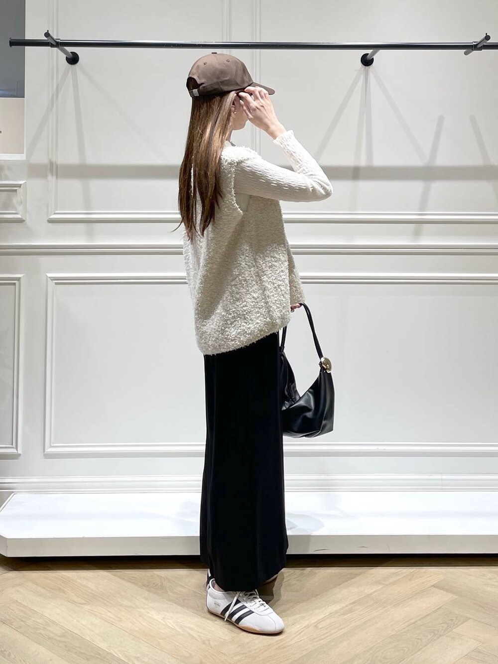 ブラック系のショルダーバッグ、ホワイト系のスニーカー、ホワイト系のTシャツ/カットソーを着用したレディースの冬コーディネートの3枚目の写真