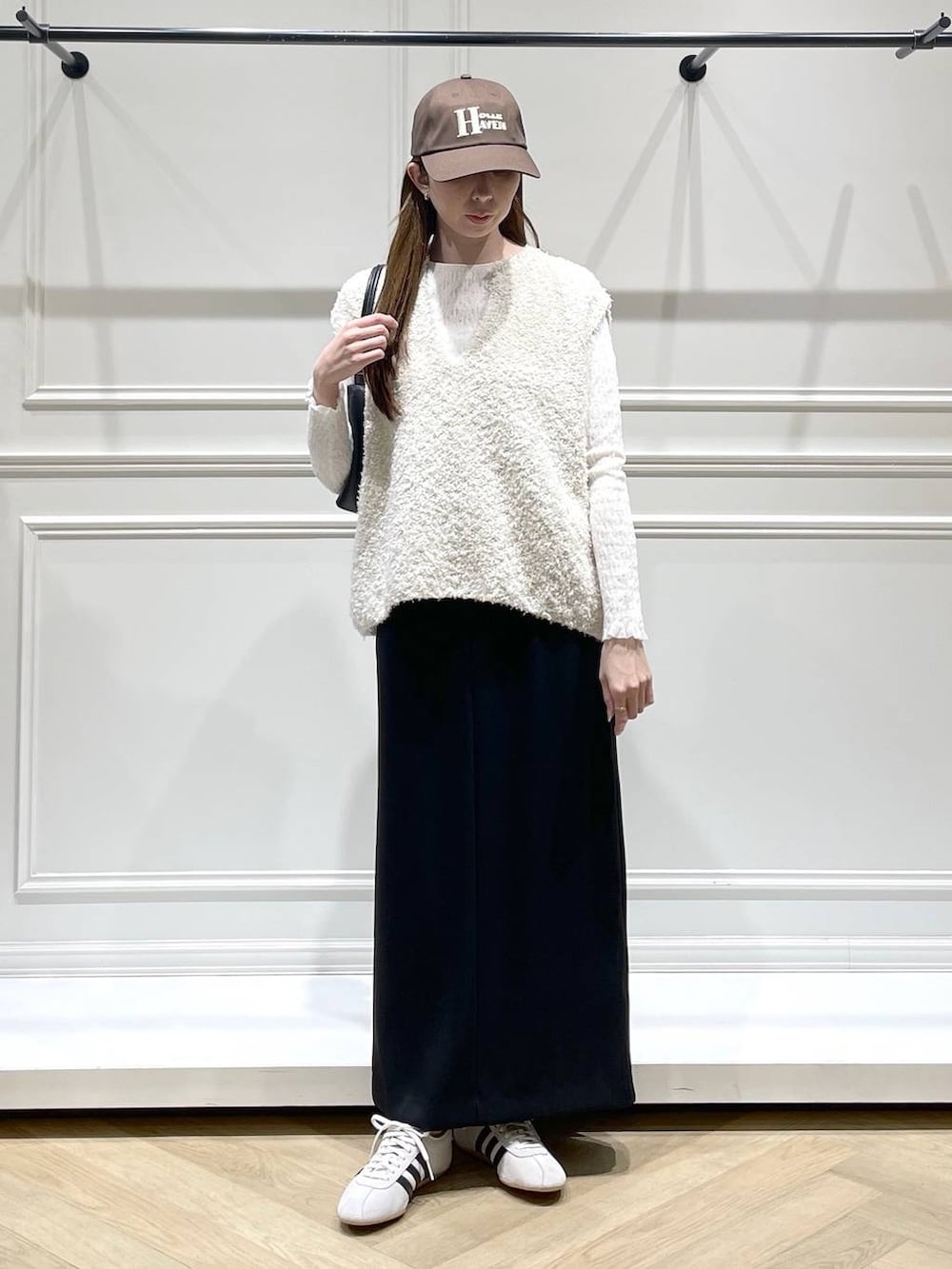 ブラック系のショルダーバッグ、ホワイト系のスニーカー、ホワイト系のTシャツ/カットソーを着用したレディースの冬コーディネートの5枚目の写真