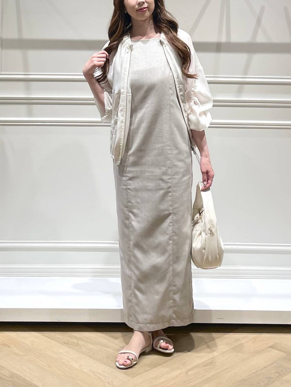 ホワイト系のハンドバッグ、ホワイト系のブルゾン、ホワイト系のサンダルを着用したレディースの春コーディネートの5枚目の写真