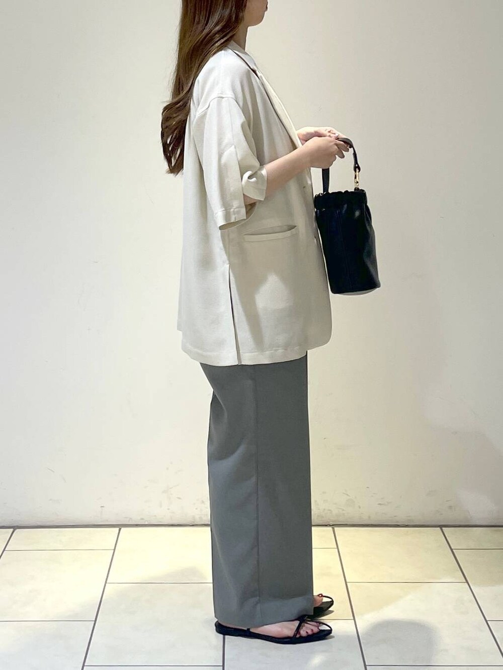 グレー系のサロペット/オーバーオール、ホワイト系のテーラードジャケット、ブラック系のサンダルを着用したレディースの夏コーディネートの3枚目の写真