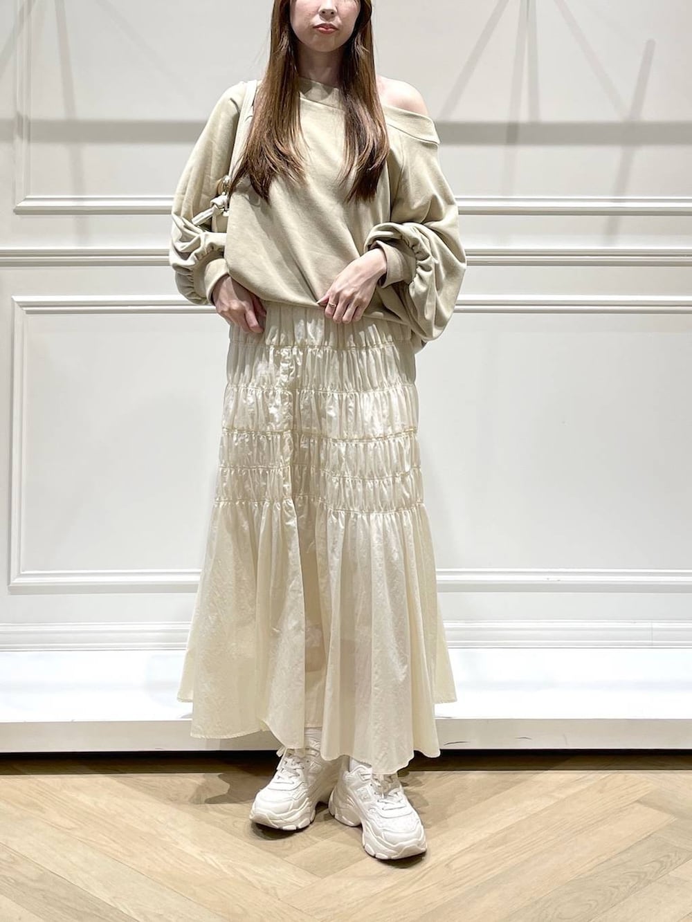 ホワイト系のスカート、ベージュ系のスウェットを着用したレディースの冬コーディネートの2枚目の写真