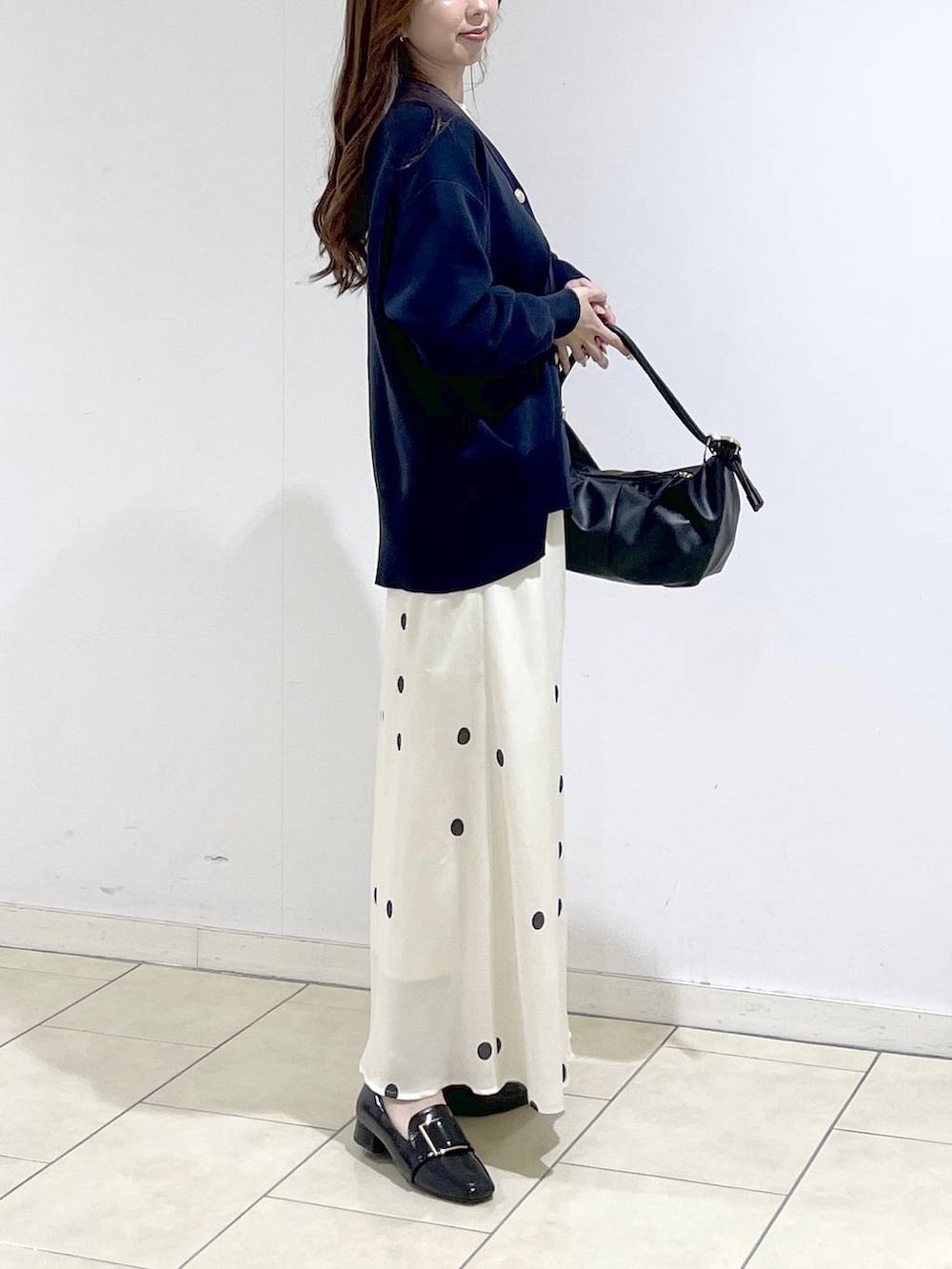 ブルー系のカーディガン/ボレロ、ホワイト系のTシャツ/カットソー、ブラック系のショルダーバッグを着用したレディースの春コーディネートの3枚目の写真