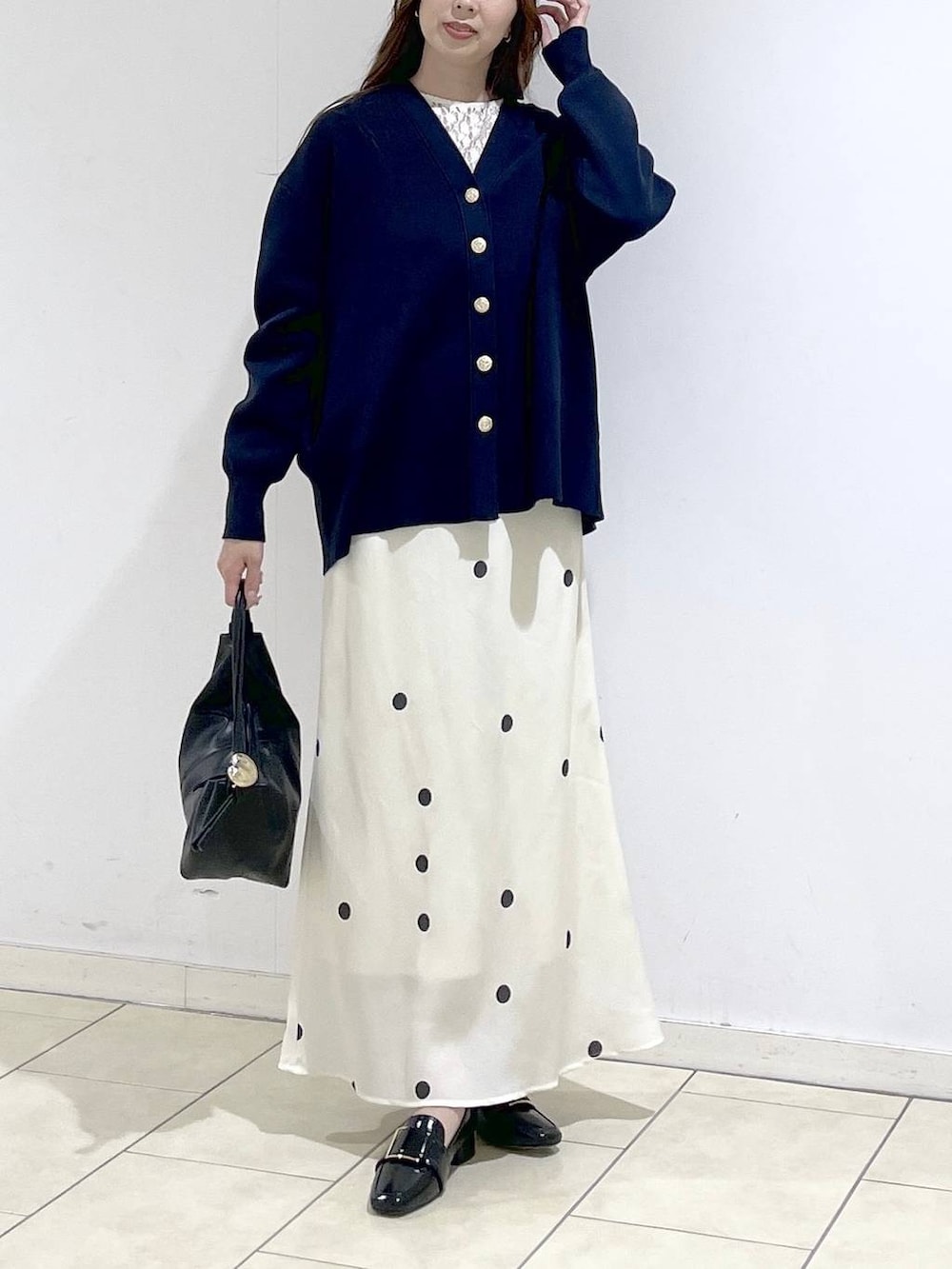 ブルー系のカーディガン/ボレロ、ホワイト系のTシャツ/カットソー、ブラック系のショルダーバッグを着用したレディースの春コーディネートの4枚目の写真
